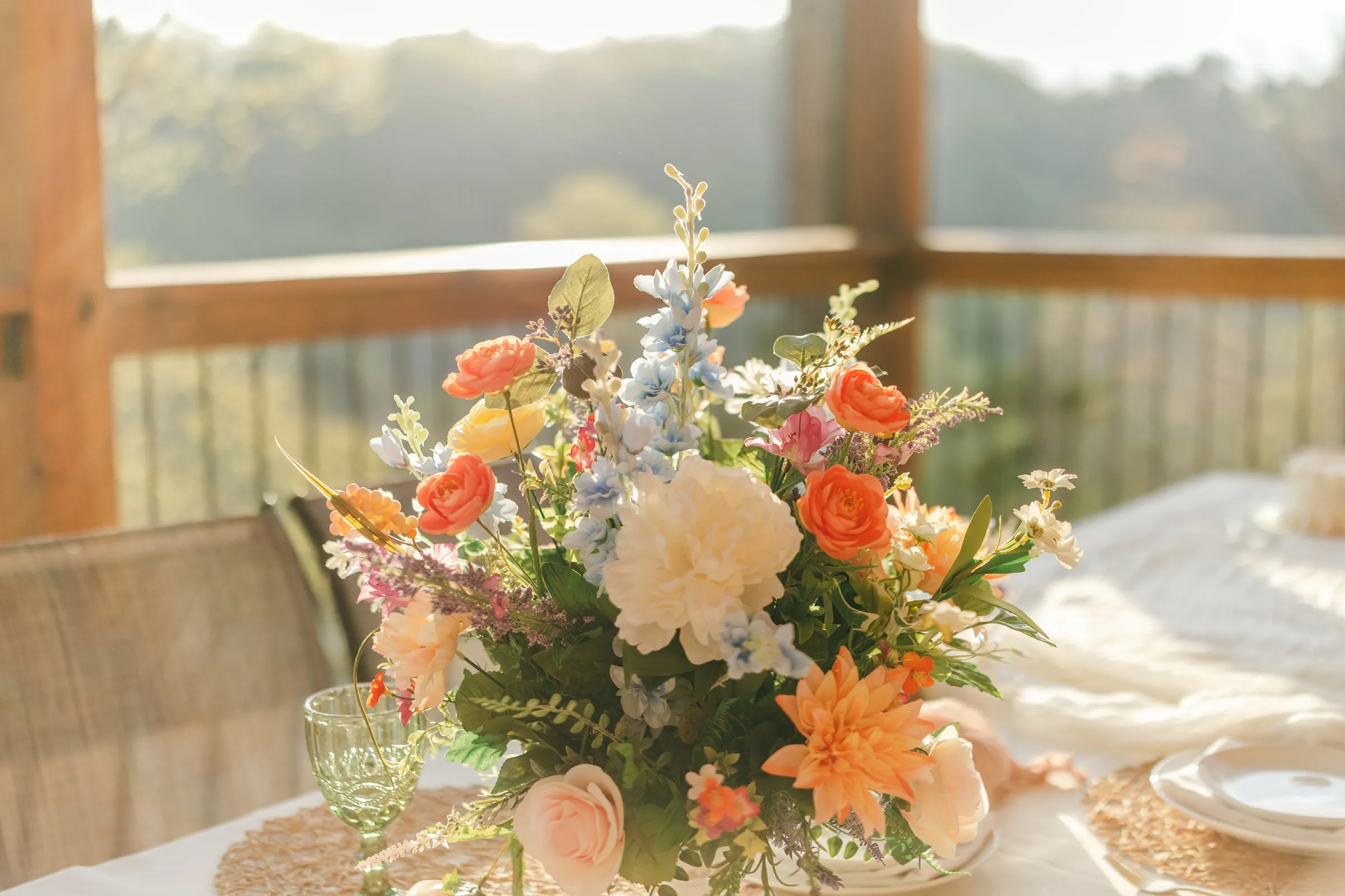 Golden-hour floral centerpiece on the reception deck overlooking the valley