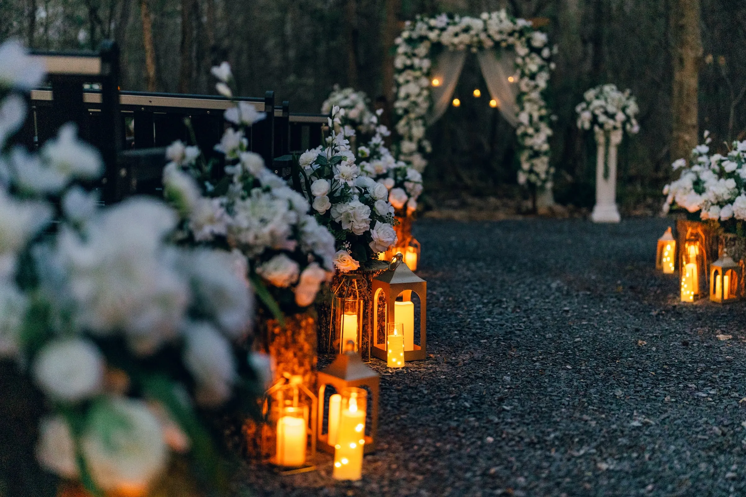 Close view of lanterns and florals lining the ceremony aisle