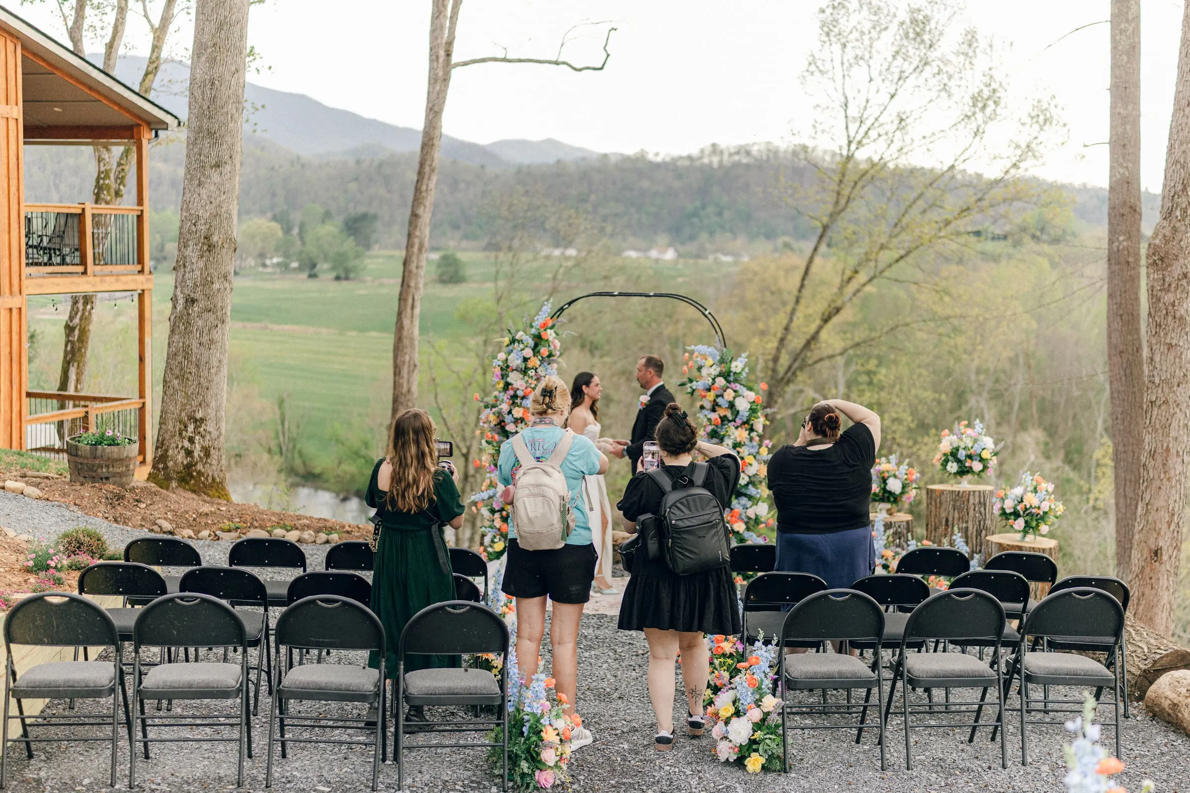 Riverside ceremony arch set against the mountain vista under an open sky