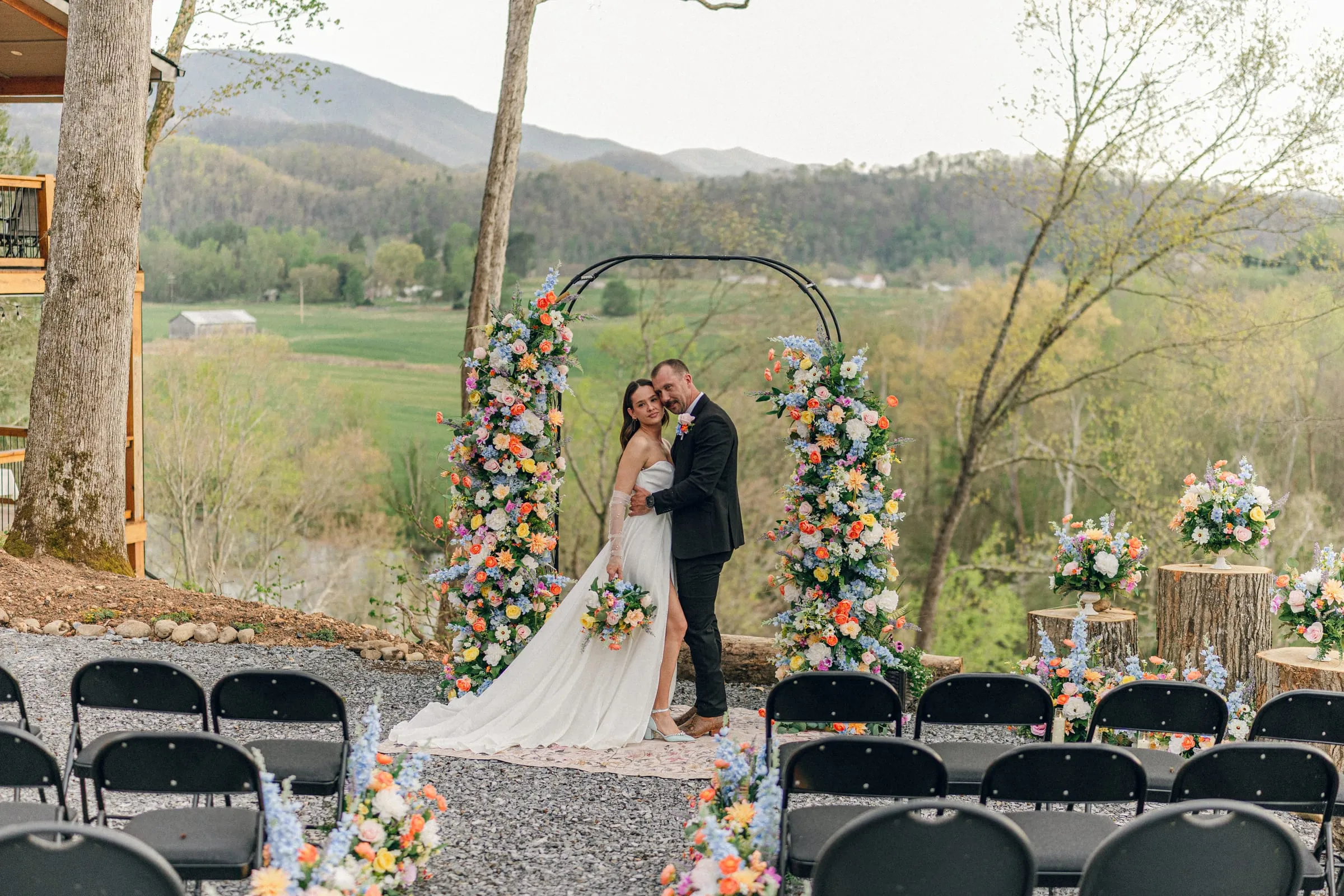 Couple at the Mountain View ceremony arch with an open mountain ridge behind them